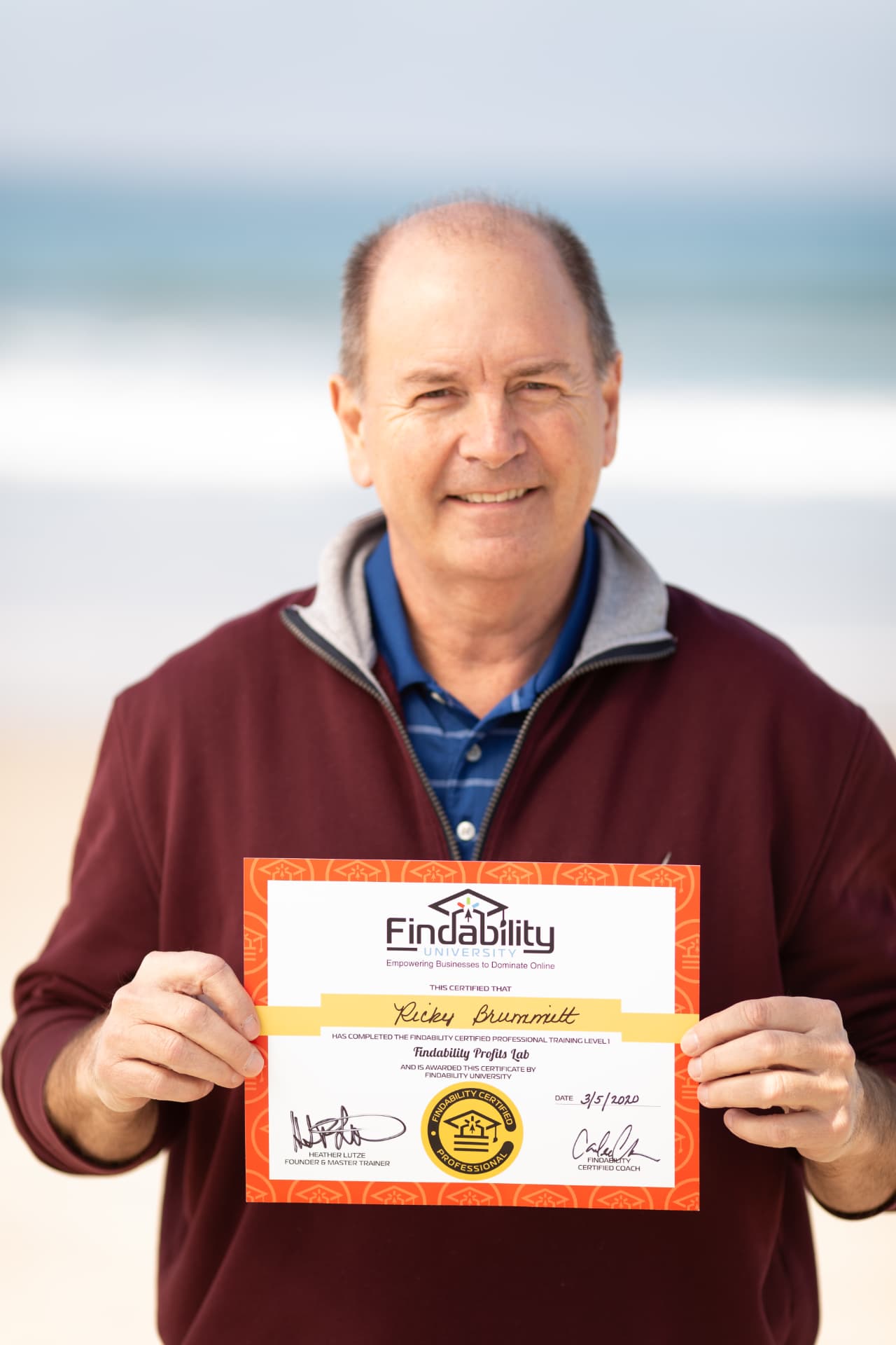 Workshop graduate holding his Findability University certificate