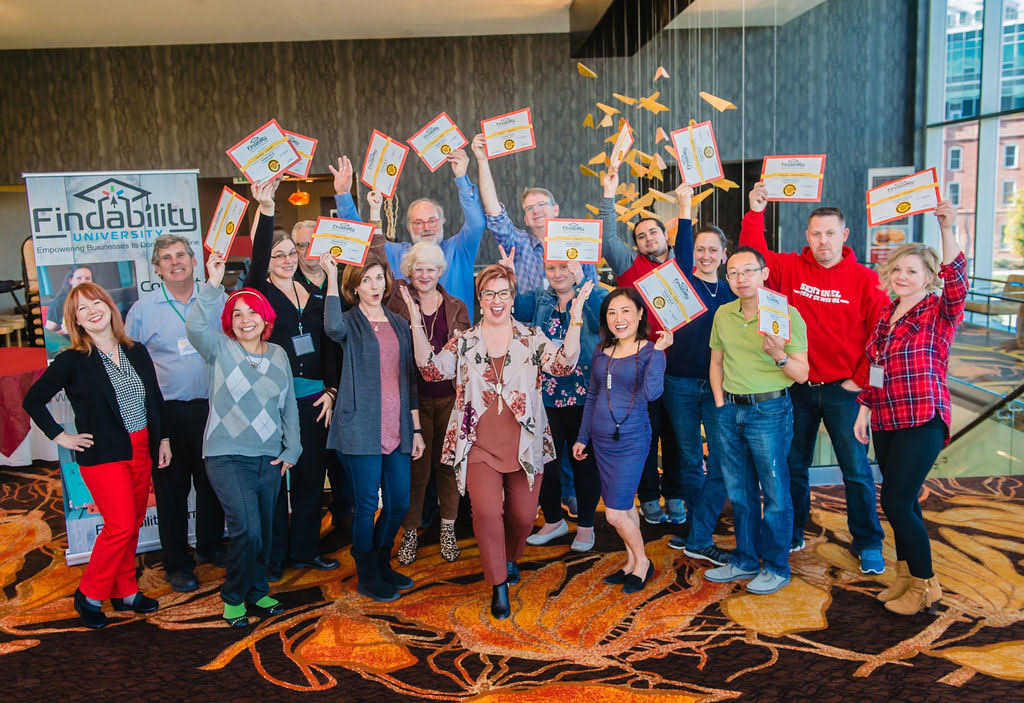 A full Findability University workshop group holding up their certificates