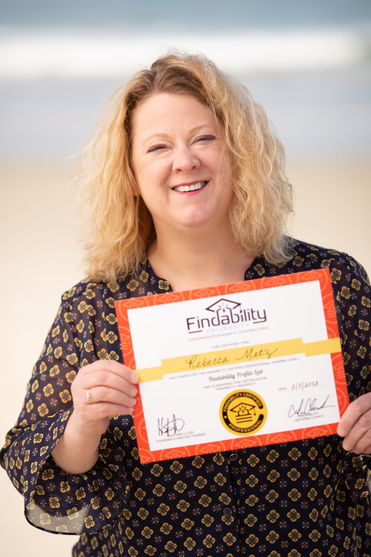 Workshop graduate holding her Findability University certificate