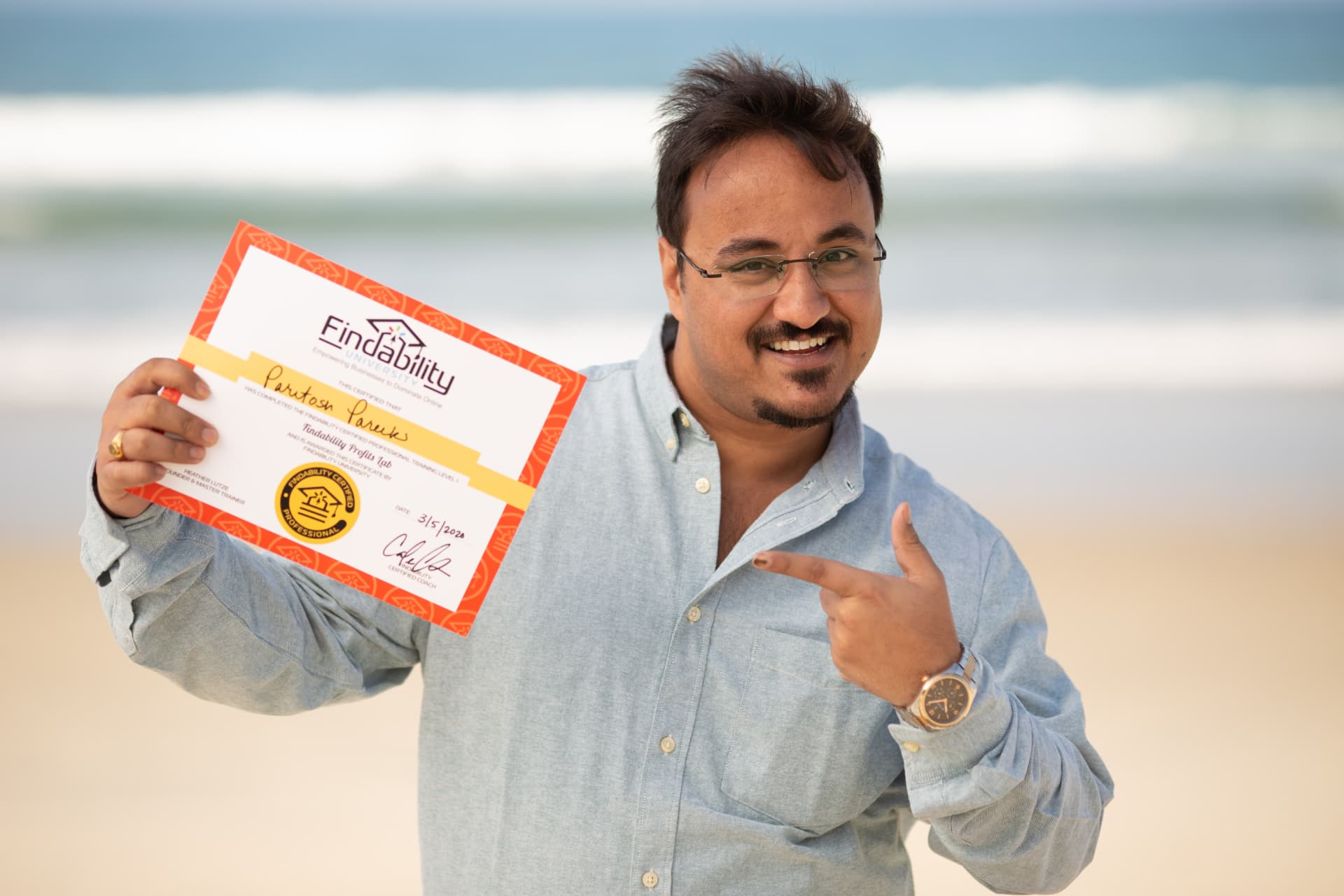 Workshop graduate pointing at his Findability University certificate
