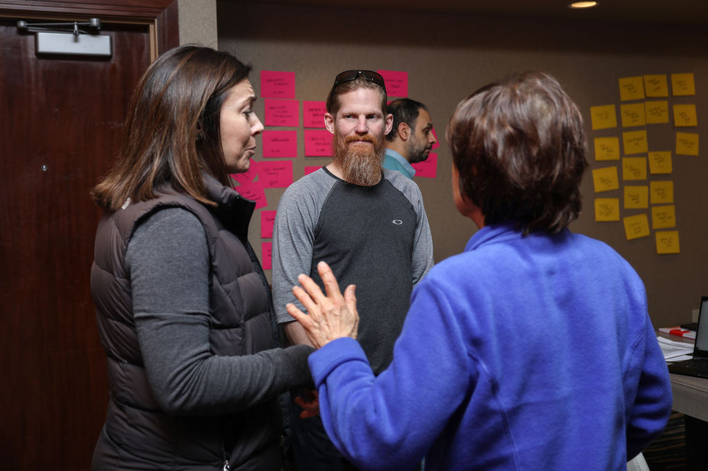 Two participants talking through a wall of sticky notes