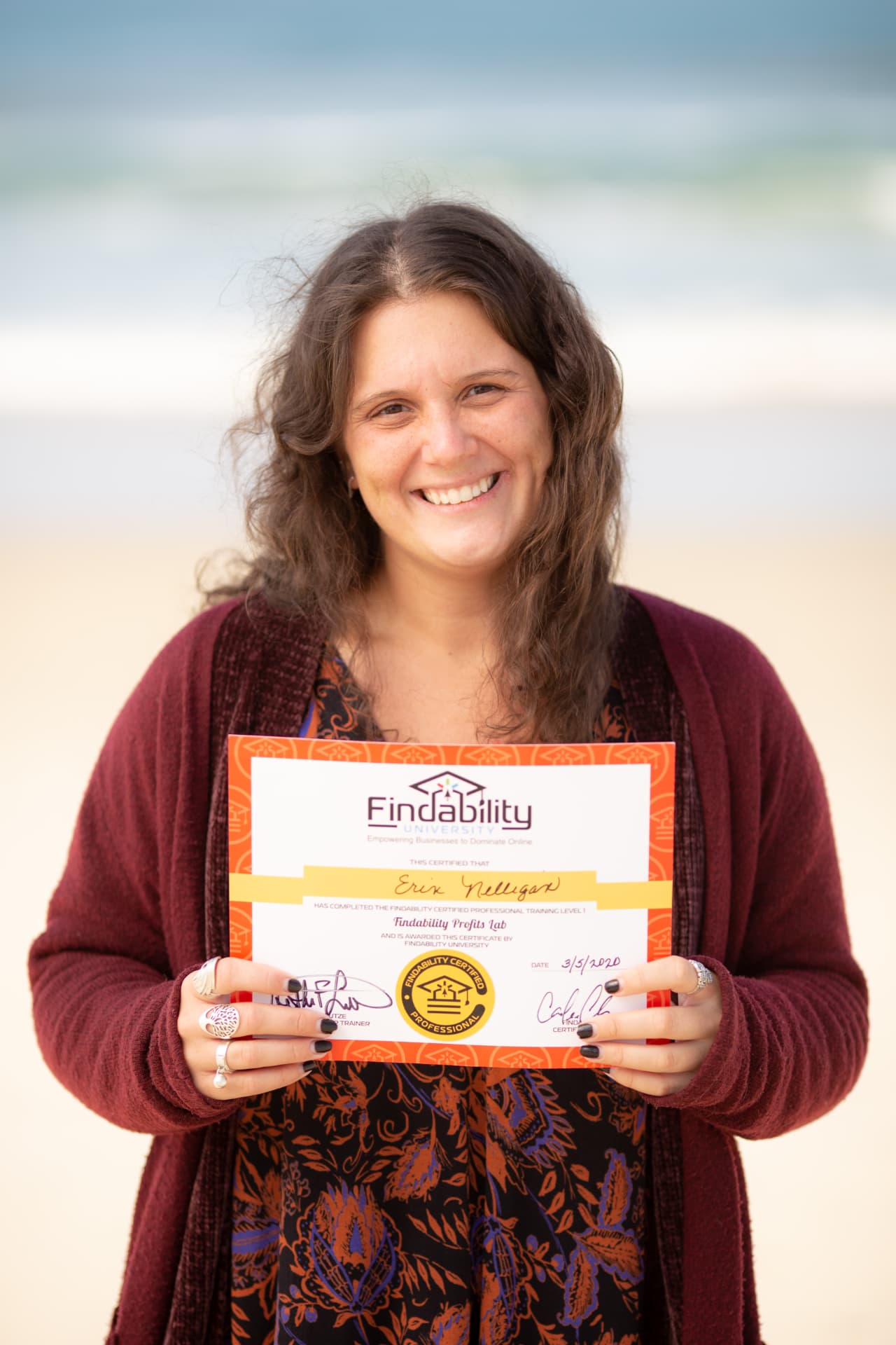 Workshop graduate holding her Findability University certificate