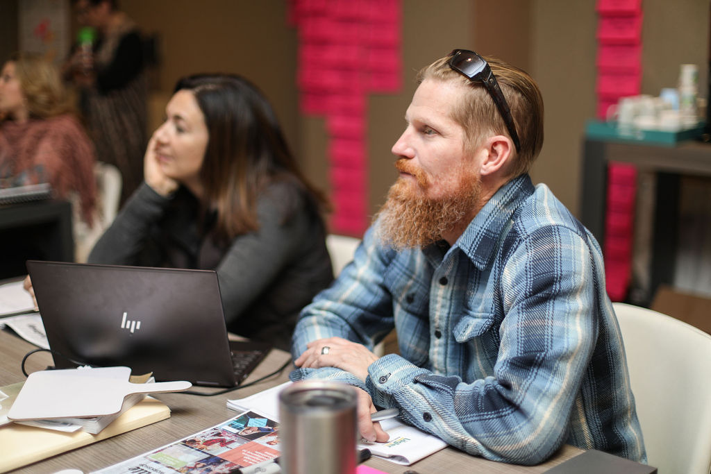 Participants working on laptops around a workshop table