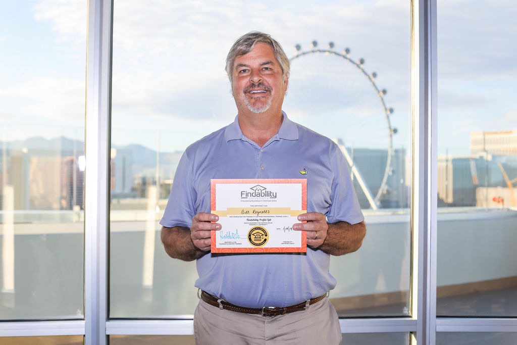 A workshop attendee holding their Findability University certificate